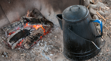cowboy coffee pot next to fire