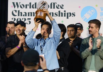WCRC 2025 4th place winner Song Chundan celebrating with his trophy at the World Coffee Championships awards stage.